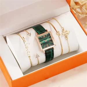 Detail of green square dial watch with gold accents and matching bracelets in a gift box