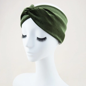 Detail of dark green velvet headband showing cross-knot texture on a mannequin