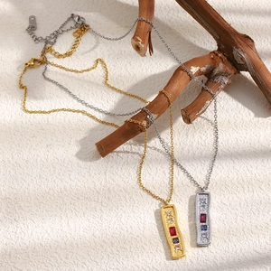 Macro detail of gold and silver rectangle necklaces with crystals on a branch