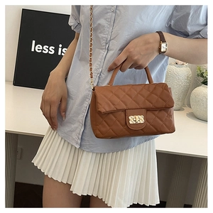 Detail of a brown quilted crossbody bag with gold-tone metal lock and chain strap