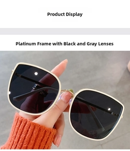 Detail shot of square oversized sunglasses with white gold frame and dark grey lenses