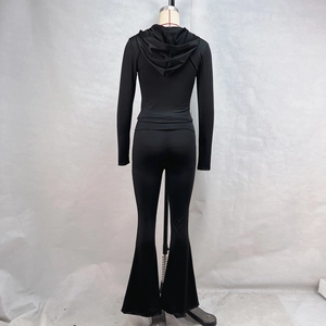 Rear view of black zip-up hoodie and flared pants set on mannequin with glossy fabric