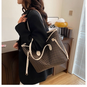 Fashionable dark brown tote bag with geometric pattern shown on model in home setting