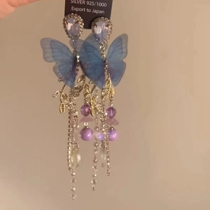 Detail of 925 silver fringe earrings with blue butterflies and purple crystal beads
