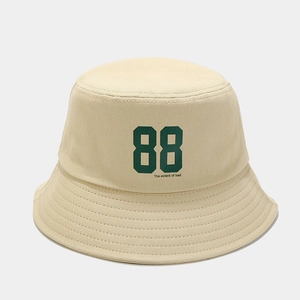 Macro shot of beige cotton bucket hat showing detailed twill fabric and green 88 print