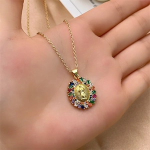 Detailed close-up of a gold Virgin Mary pendant with colorful rectangular zircon stones