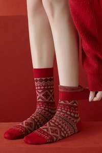 Gros plan détaillé de chaussettes en laine rouge épaisse avec motifs Fair Isle et côtes