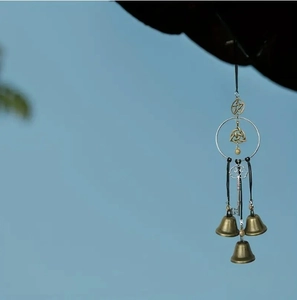 Detailed view of witch bells with brass bells, pentagram charm and a vintage key