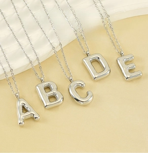 Detail of 3D puffy bubble letter pendants A to E on a polished stainless steel chain