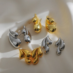 Detailed view of teardrop and leaf shaped earrings in gold and silver finish