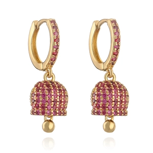 Macro shot of gold-plated bell earrings with pavé set red zircon crystals and small drops