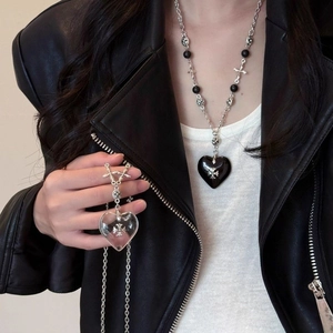 Close-up of stone beaded necklace with heart cross pendant worn by a female model