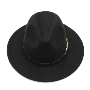 Detailed macro view of black wide brim fedora with gold metal chain buckle and band