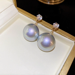 Vue macro de boucles d'oreilles perles Aurora avec zircone ronde en boîte à bijoux