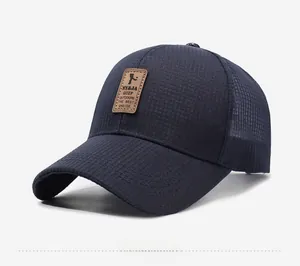 Detail of navy blue baseball cap featuring breathable mesh and brown leather logo patch
