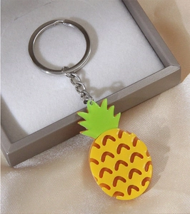 Gros plan détaillé d'un porte-clés ananas jaune avec anneau dans un coffret
