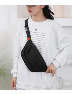 Close-up of black nylon chest bag with adjustable strap worn by model in studio