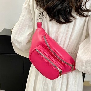 Fashionable rose pink waist bag with silver chain strap shown on model over white dress
