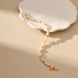Detailed view of natural freshwater pearls and 18K gold-plated OT buckle on shell tray