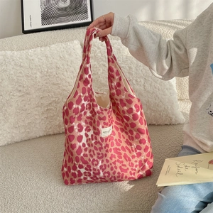 Detail of pink leopard print canvas tote bag with woven label and soft fabric texture