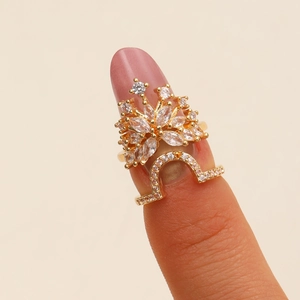 Golden crown nail ring with clear marquise cubic zirconia stones on pink manicure
