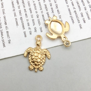 Detailed view of antique gold sea turtle charms showing shell texture and smooth back side