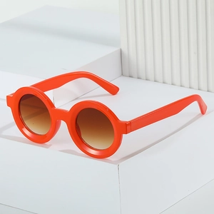 Fashionable round sunglasses with orange frames and brown gradient lenses on geometric base