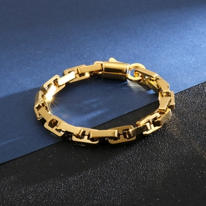 Close-up of golden geometric chain bracelet featuring unique H-shaped links and cylinder clasp