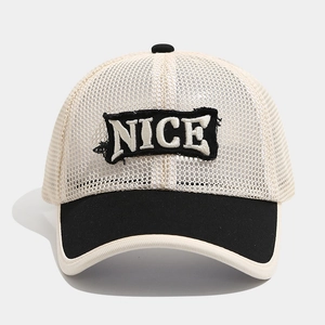 Detail of breathable mesh trucker hat with black NICE embroidered patch on beige front