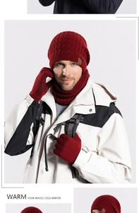 Close-up of red winter knit set including hat with leather patch, scarf and gloves