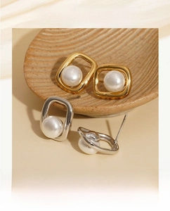 Detailed close-up of geometric square earrings with pearls in gold and silver finishes