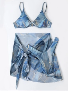 Detailed flat lay of blue marble print three-piece bikini set with sheer mesh sarong