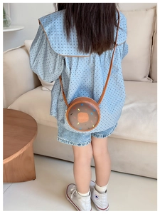 Macro shot of a chocolate brown donut-shaped kids shoulder bag with Hello lettering