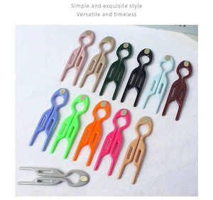 Flat lay of colorful U-shaped wave hairpins in twelve matte finishes on textured background
