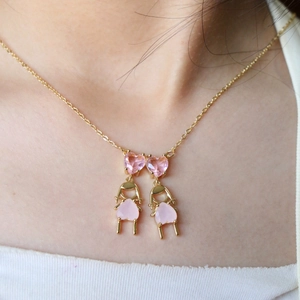 Collier minimaliste en or avec pendentifs filles en cristal de cœur sur col blanc