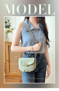 Détail du sac à bandoulière en cuir plissé vert clair avec boucle coeur doré et chaîne