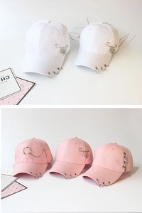 Detail of trendy baseball cap with unique metal rings and chain decorations in pink and white