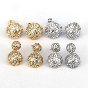 Macro shot of geometric pave-set crystal ball stud earrings in gold and silver finishes