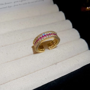 Vista macro dell'anello placcato oro 18k con incastonatura di zirconi rossi e bianchi