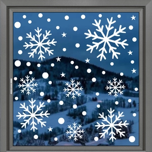 Detailed view of white snowflake window clings on glass with a winter mountain background