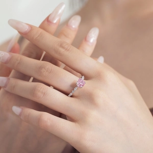 Detailed shot of cushion cut pink gemstone ring with diamond accents on a silver band