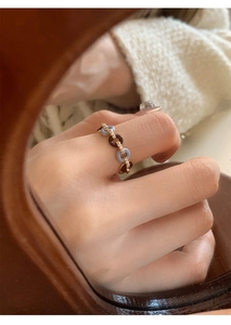 Artistic close-up of a vintage-style blue and amber resin ring on a reflective surface
