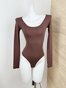 Close-up of brown long sleeve bodysuit with U-neck design and ribbed cotton texture