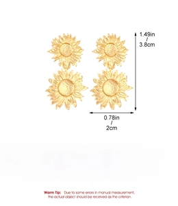 Detail view of gold sunflower earrings with size and weight specifications on white background