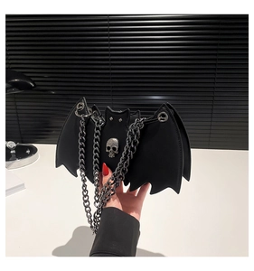 Detail shot of gothic bat shaped purse featuring matte leather texture and silver skull charm