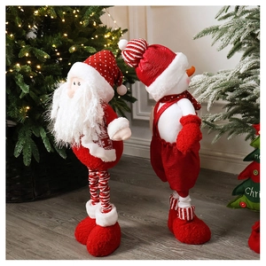 Standing Christmas Santa and Snowman plush dolls on wooden floor near a glowing tree