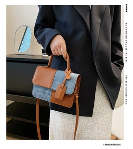 Detail of contrast patchwork handbag featuring brown leather and blue denim texture