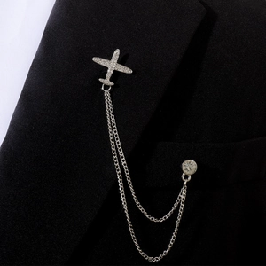 Broche avion argentée avec strass et double chaînes sur revers de veste noir