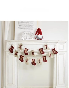 Detail view of Merry Christmas stocking garland with red plaid fabric on a cozy white fireplace