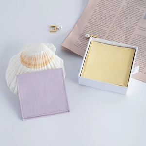 Macro shot of light purple velvet jewelry pouch displayed with a white gift box